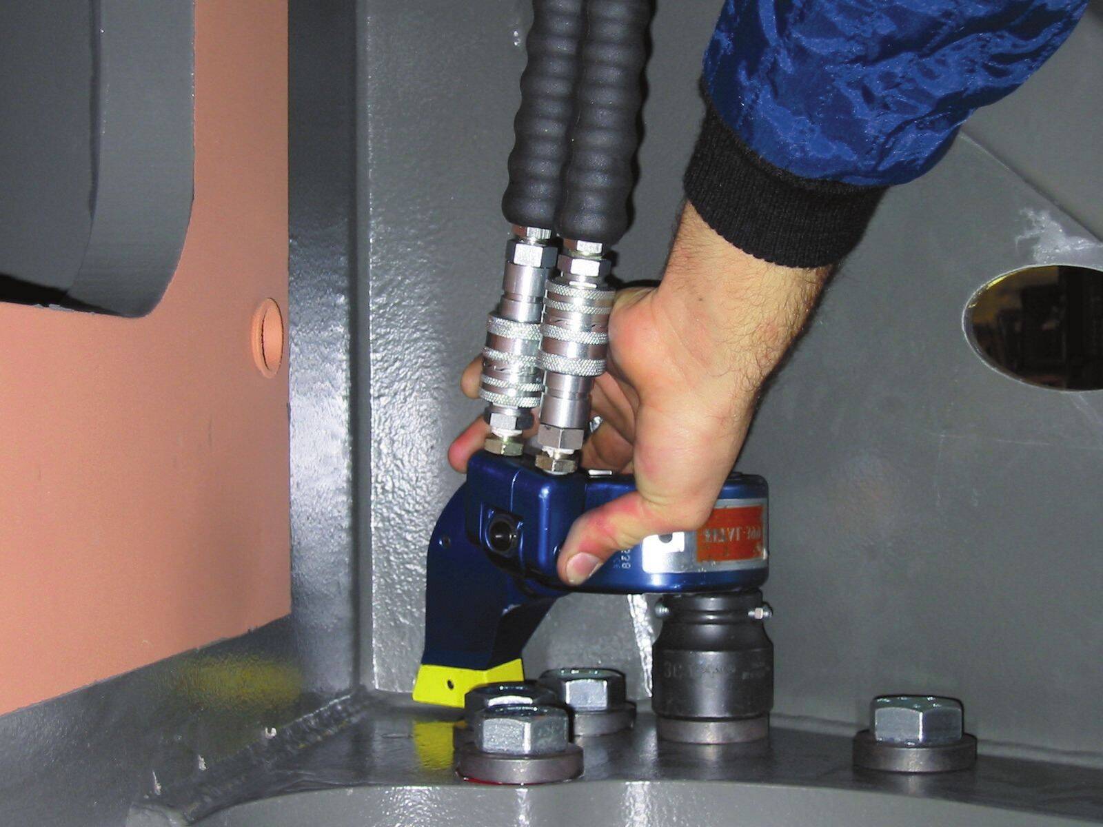 Técnico ajustando bulonería de brida con llave MXT™ sobre equipo de planta