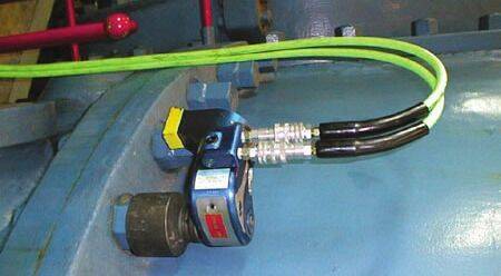 Llave MXT™ conectada mediante mangueras hidráulicas sobre superficie curva de tanque